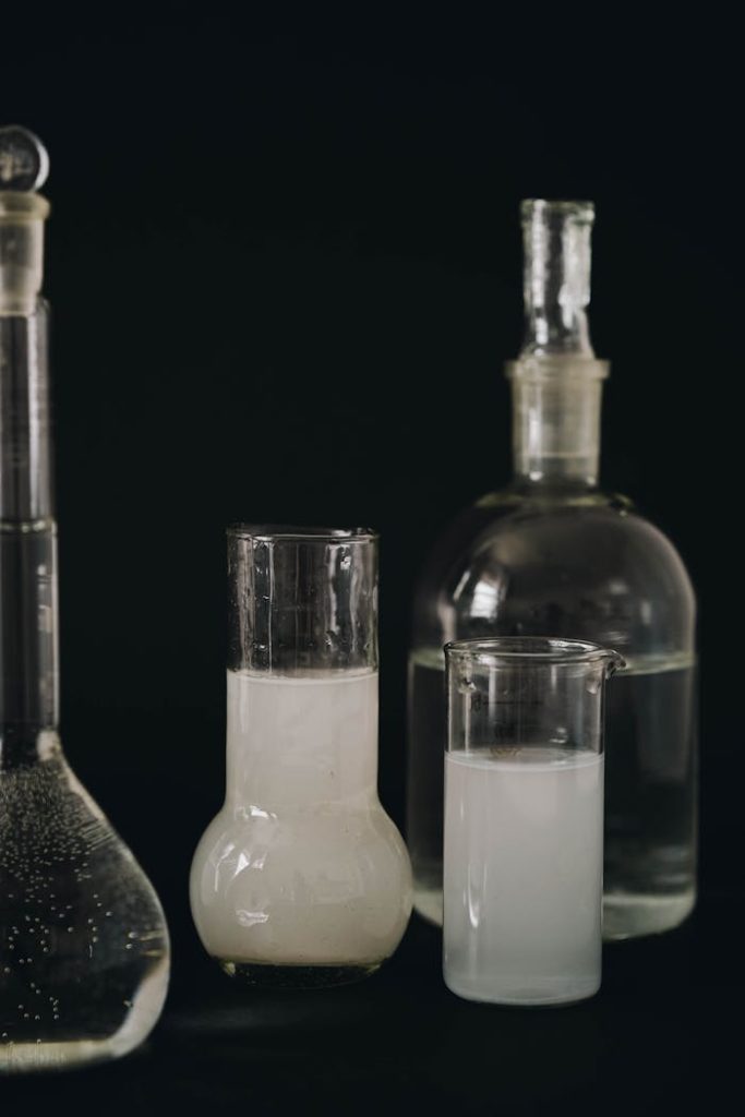 Various laboratory glassware containing liquids in a lab setting.
